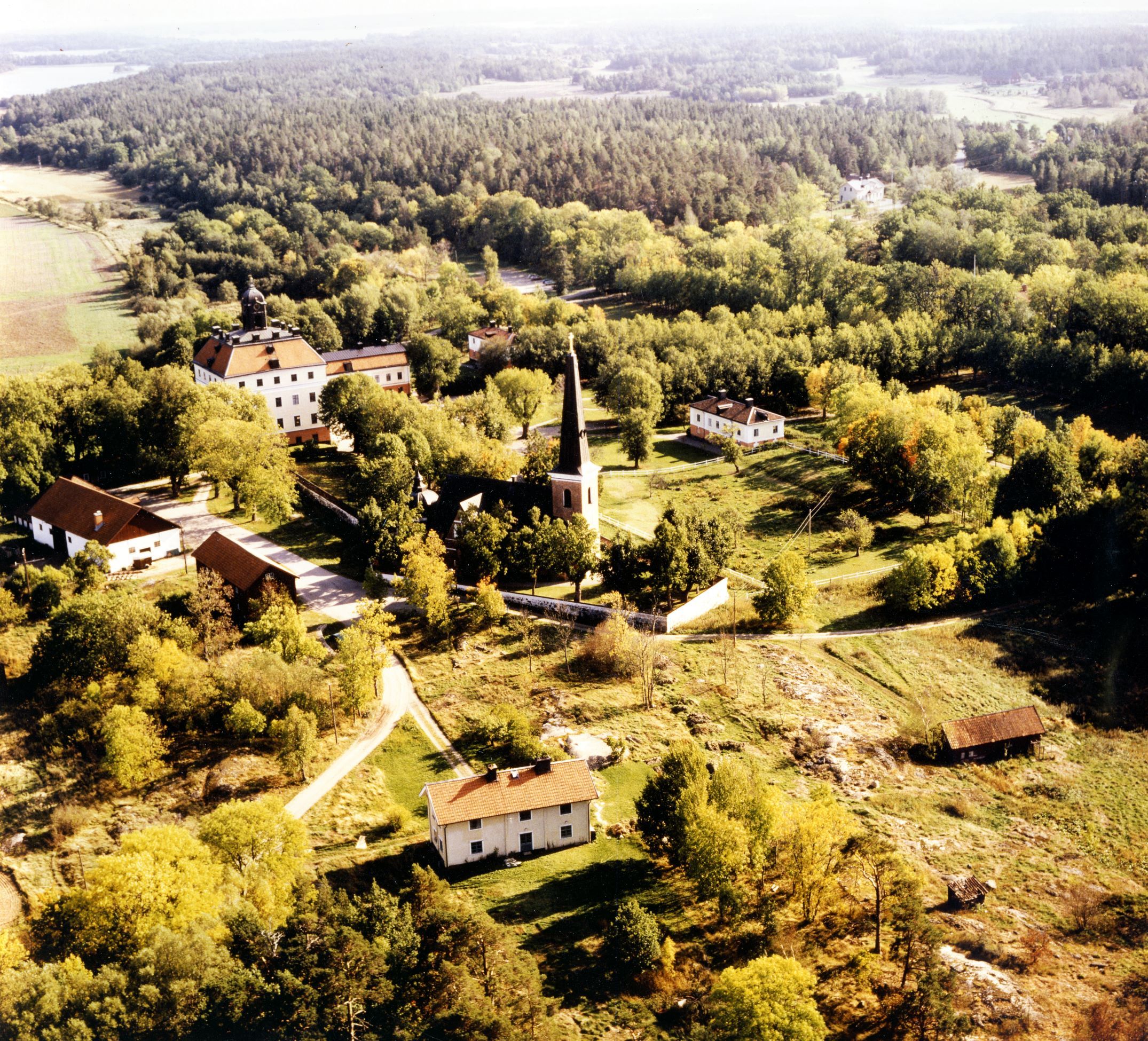 Flygfoto över Ängsö med slottet, kyrkan och andra byggnader.
