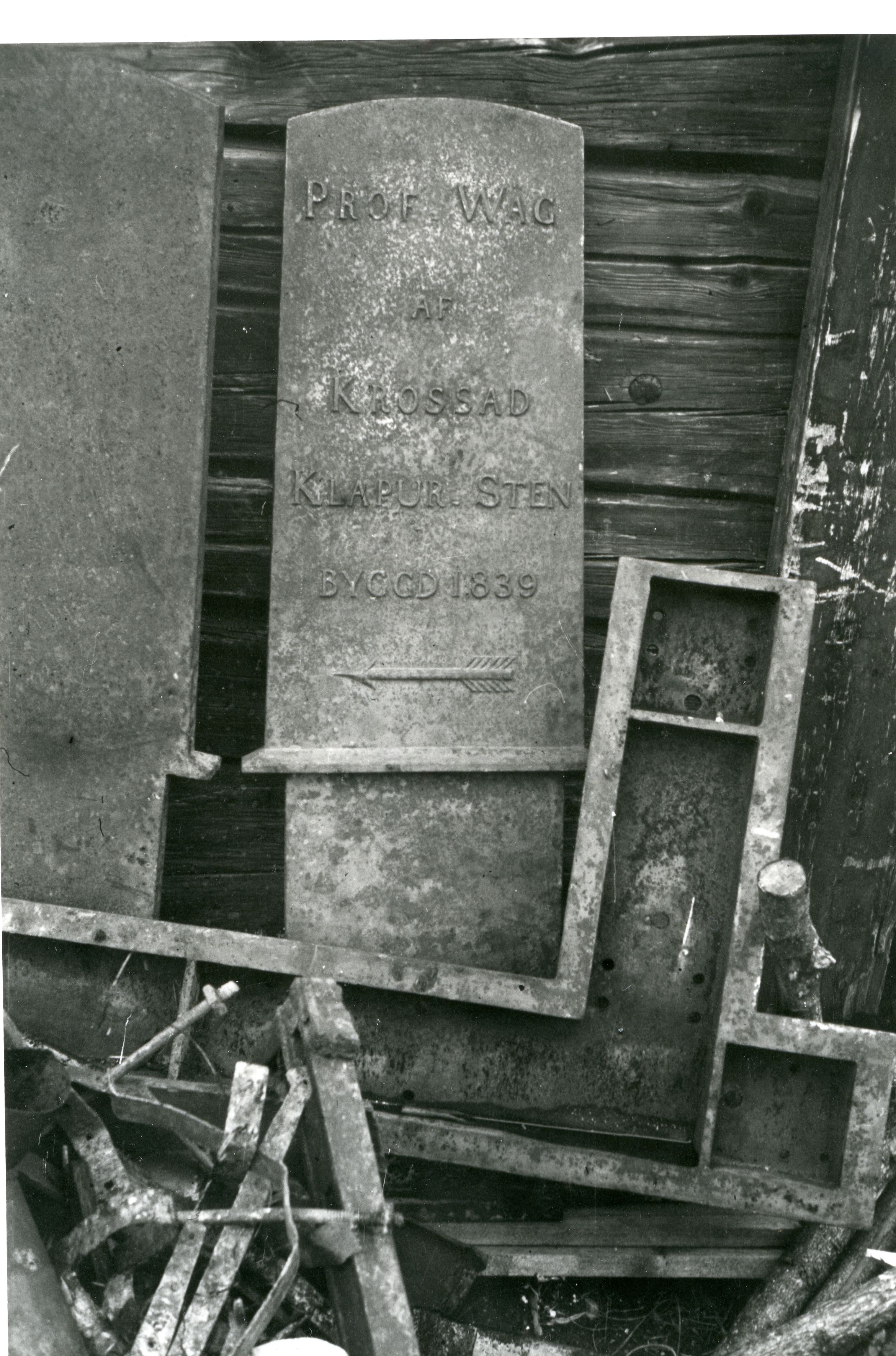 Ett vägmärke i järn med texten "PROF WÄG AF KROSSAD KLAPUR STEN BYGGD 1839"