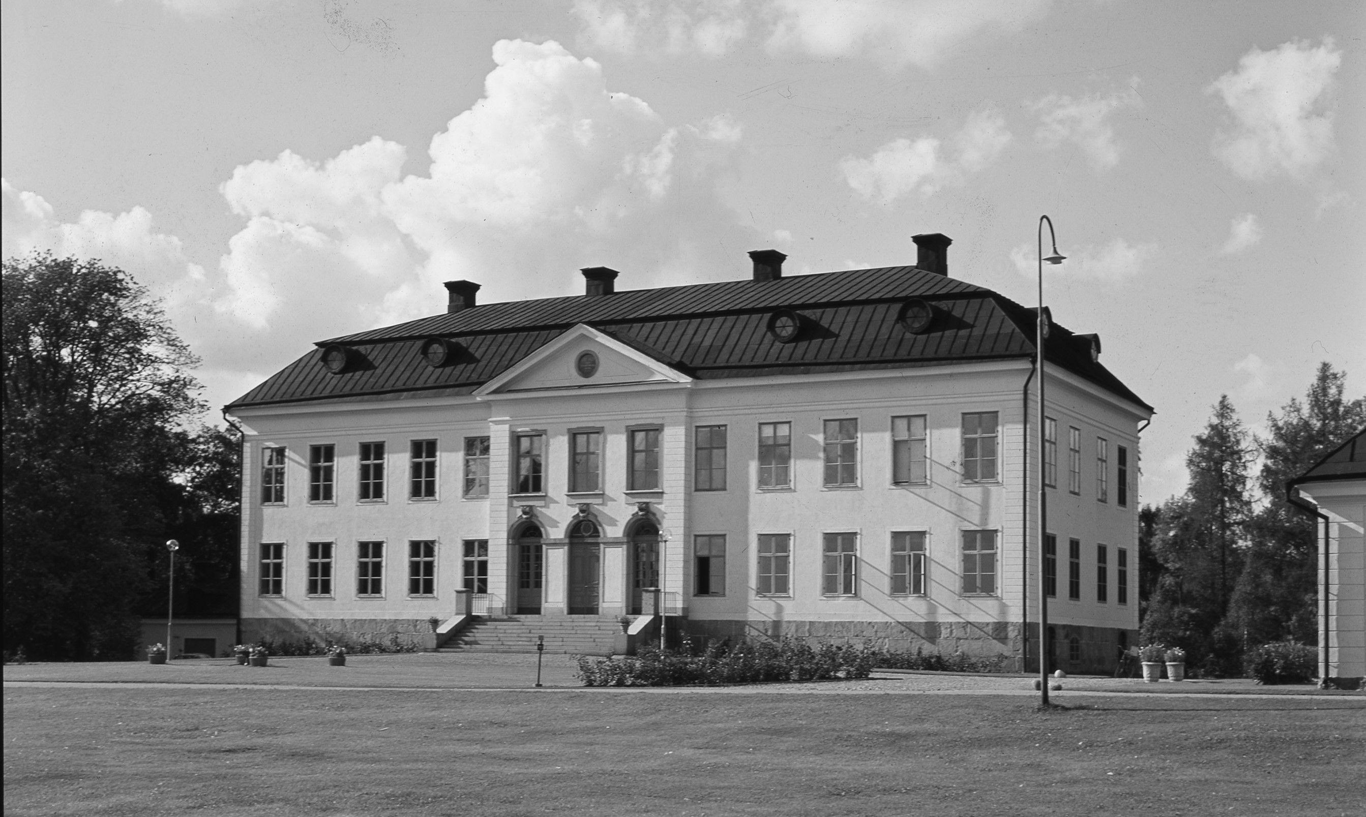 En vit herrgårdsbyggnad i två våningar.