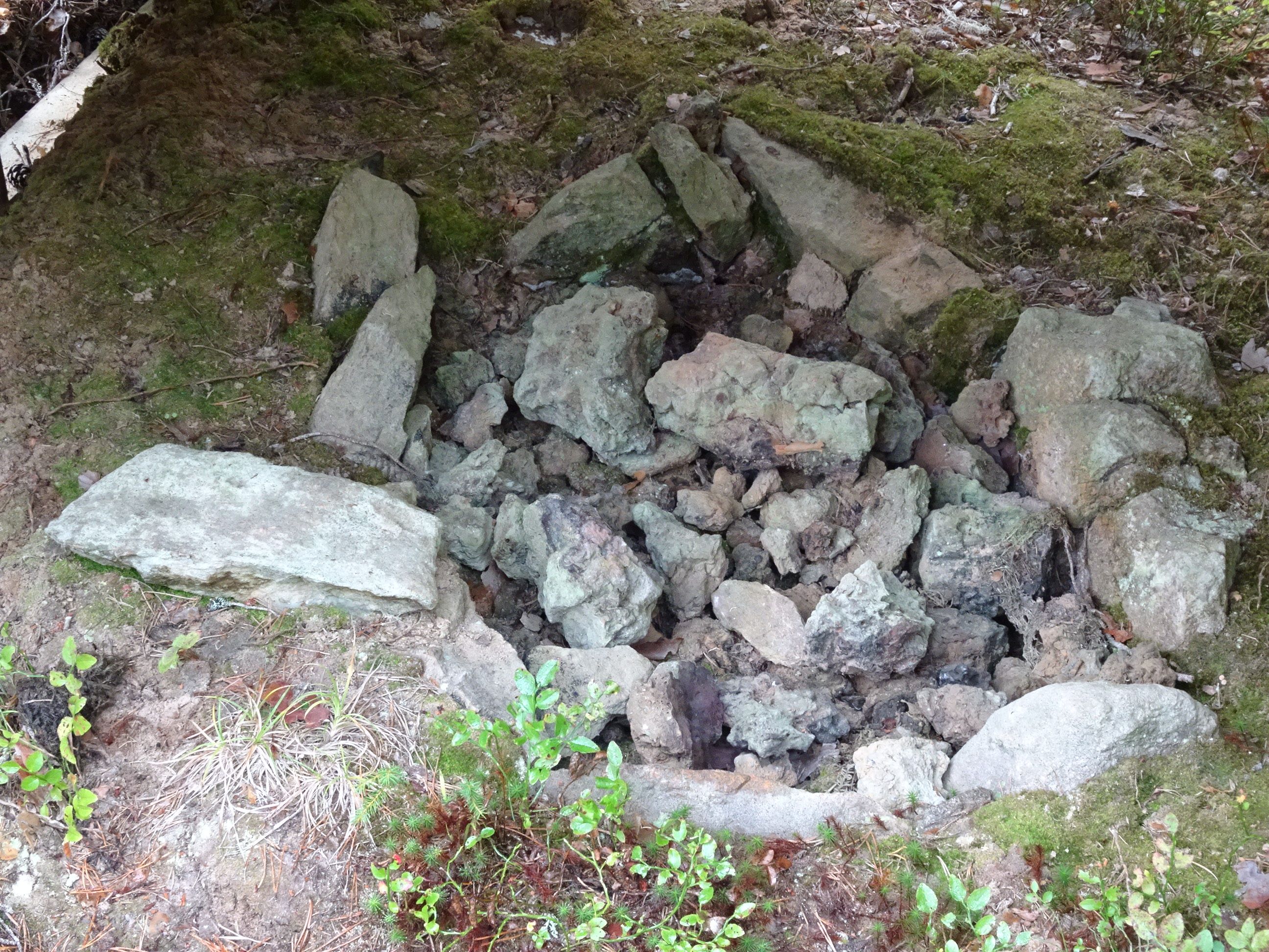 Bilden visar stenar som ligger i botten av en grop.